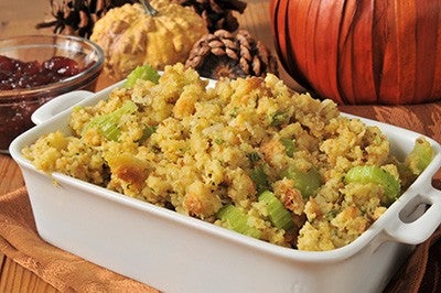 A bakilng dish of cornbread stuffing iwth celery and turkey bits