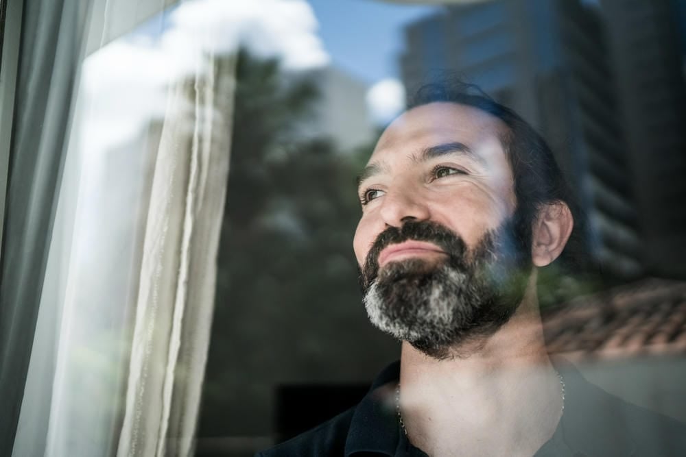 Hombre mirando a través de una ventana