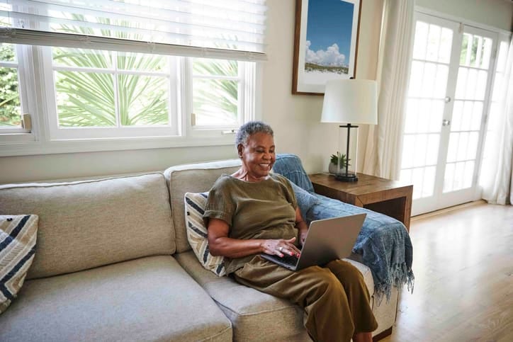 A person using a laptop at home to search for a licensed therapist online.