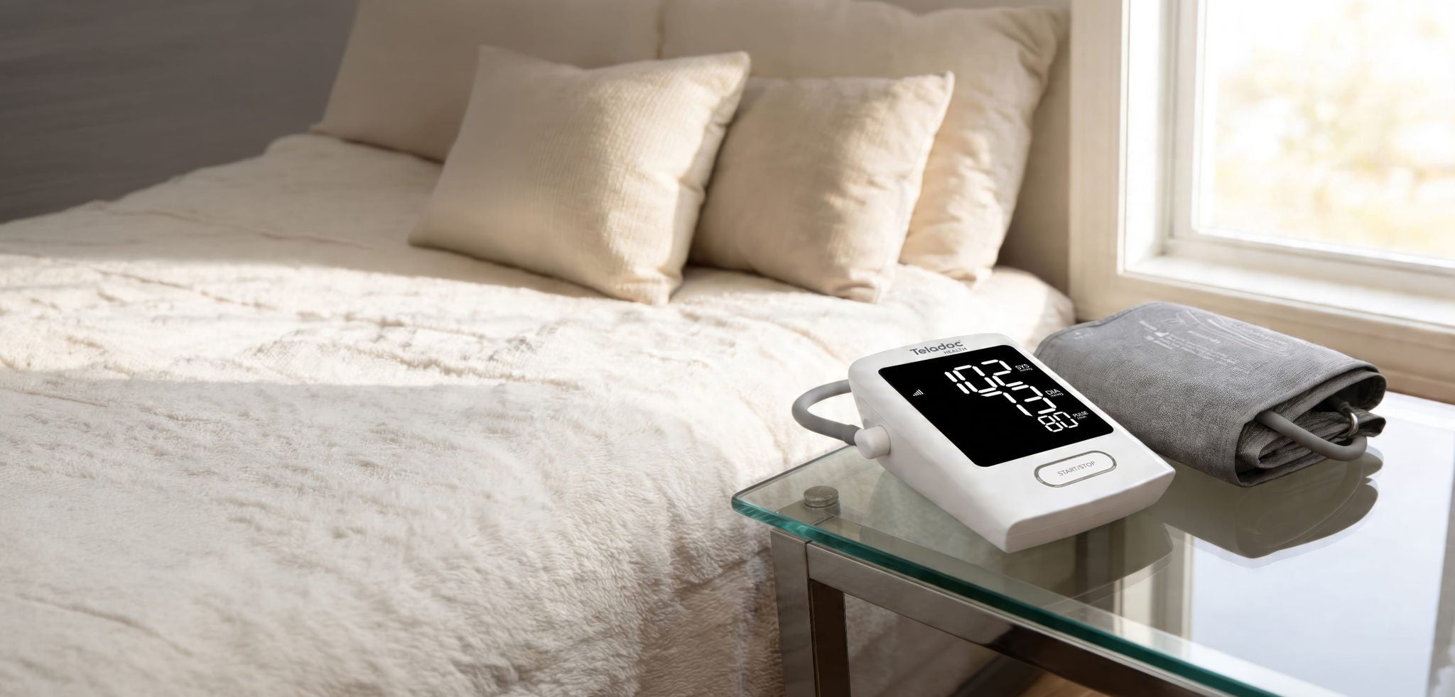 Room with an empty bed with a blood pressure monitor on the side table