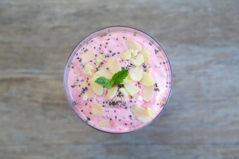 Bowl of watermelon and chia seed smoothie with coconut flakes on top.