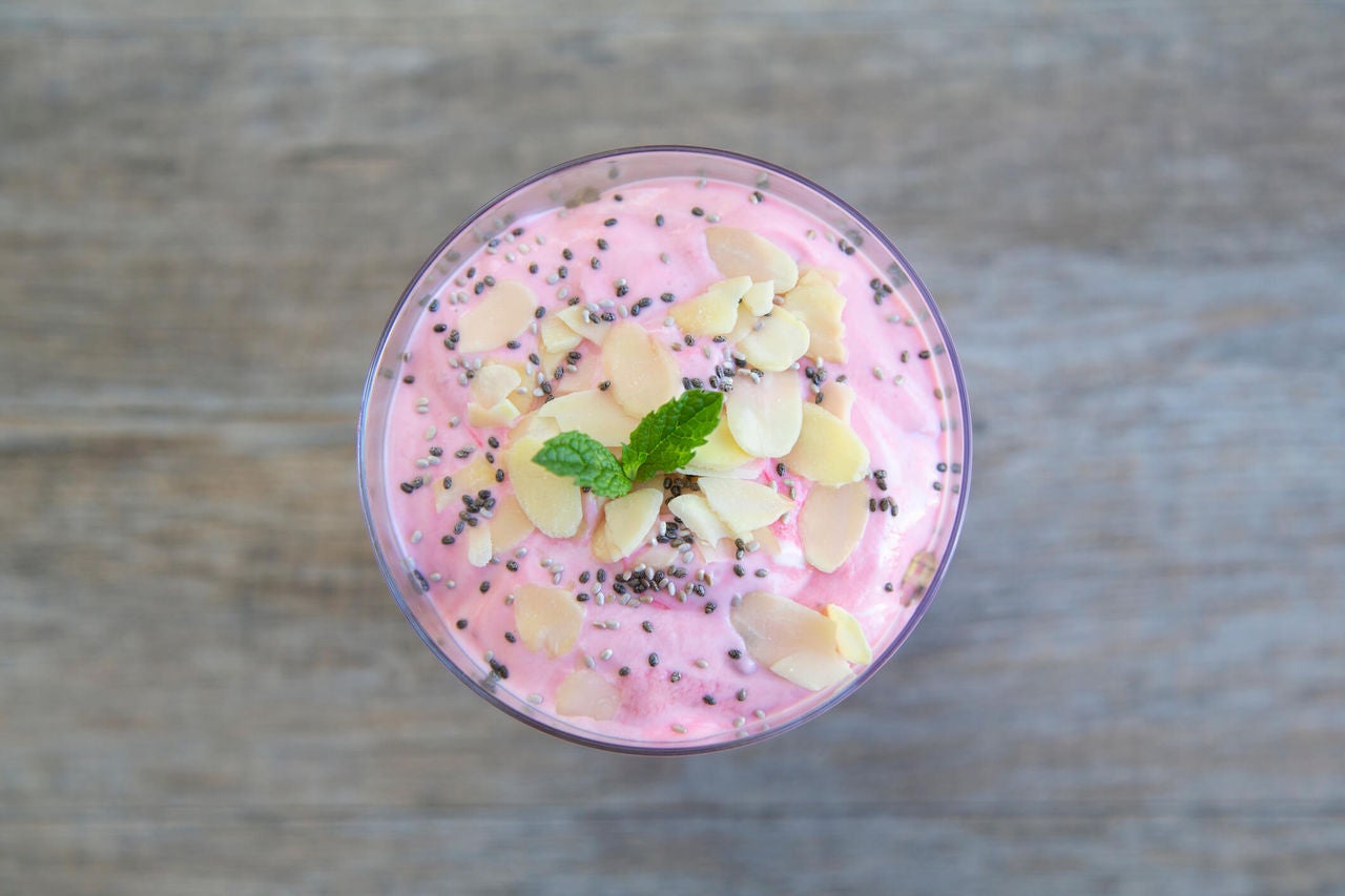 Bowl of watermelon chia seed smoothie with coconut chips on top. 