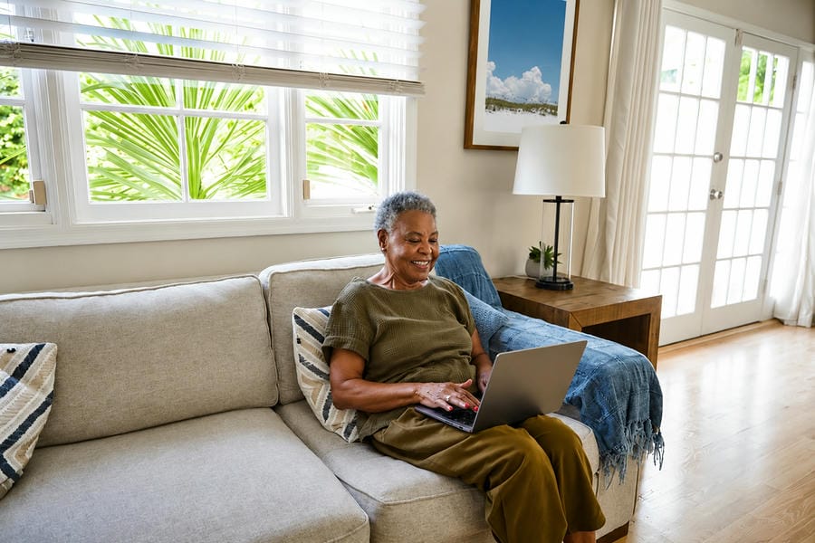 A person using a laptop at home to search for a licensed therapist online.