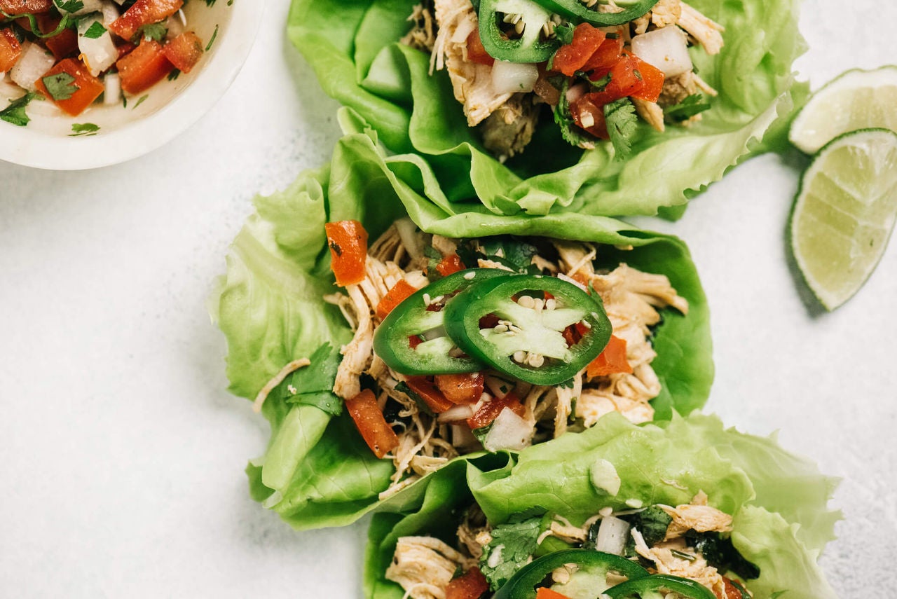 Lettuce wraps with shredded chicken, tomatoes, onions and jalapeños for garnish.
