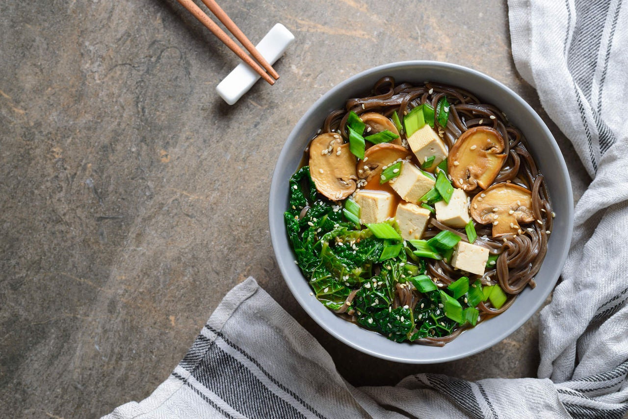 Bowl with soba noodles, mushrooms, tofu and greens.