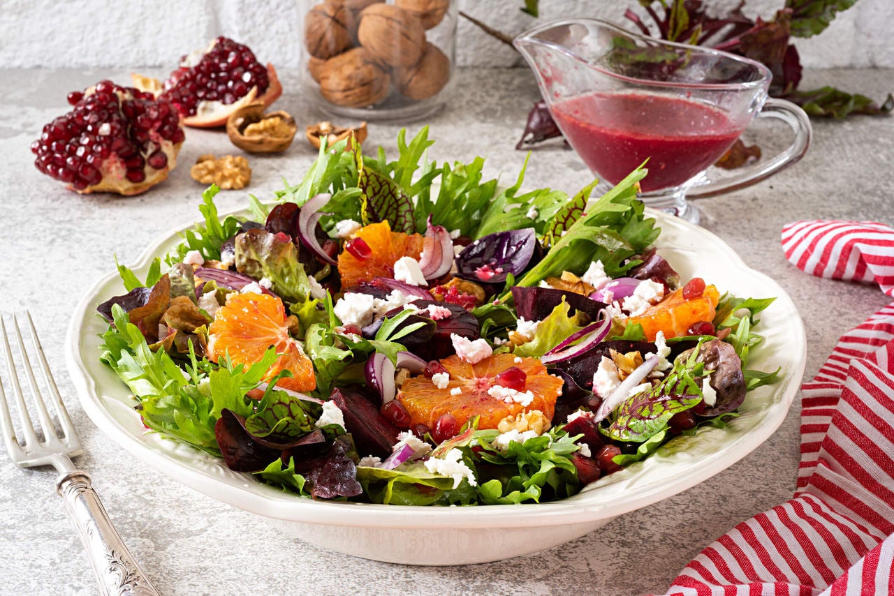 Salad with orange slices, pomegranate arils, red onion and feta cheese. 