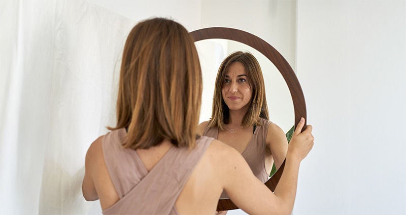 Young woman looking in the mirror