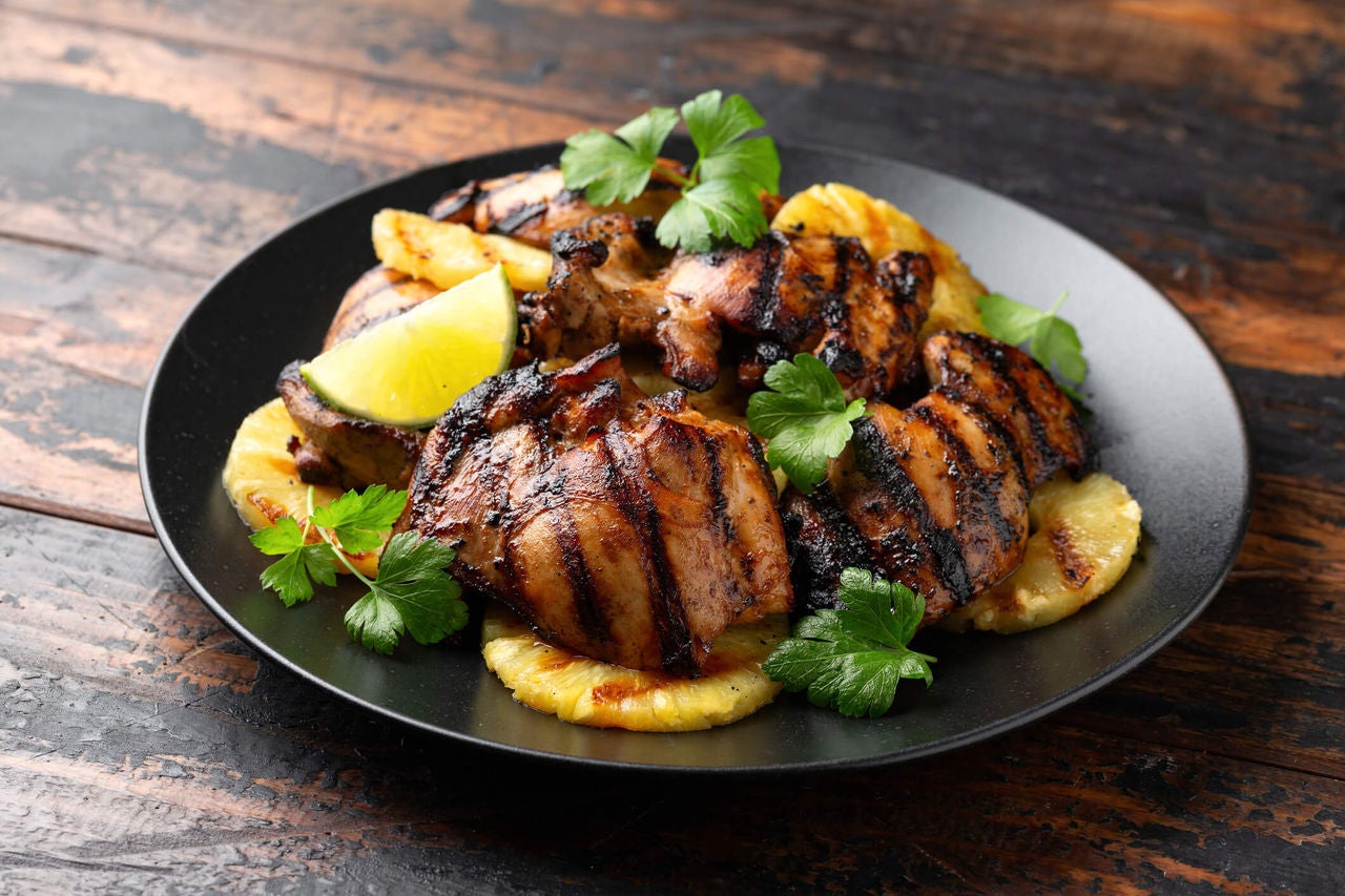 Grilled chicken with grilled pineapple rings and cilantro.