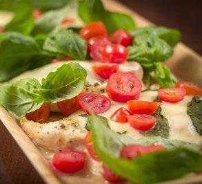 Balsamic glazed chicken topped with melted cheese, cherry tomatoes, and fresh basil leaves.