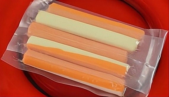 Package of cheese sticks on a red plate.