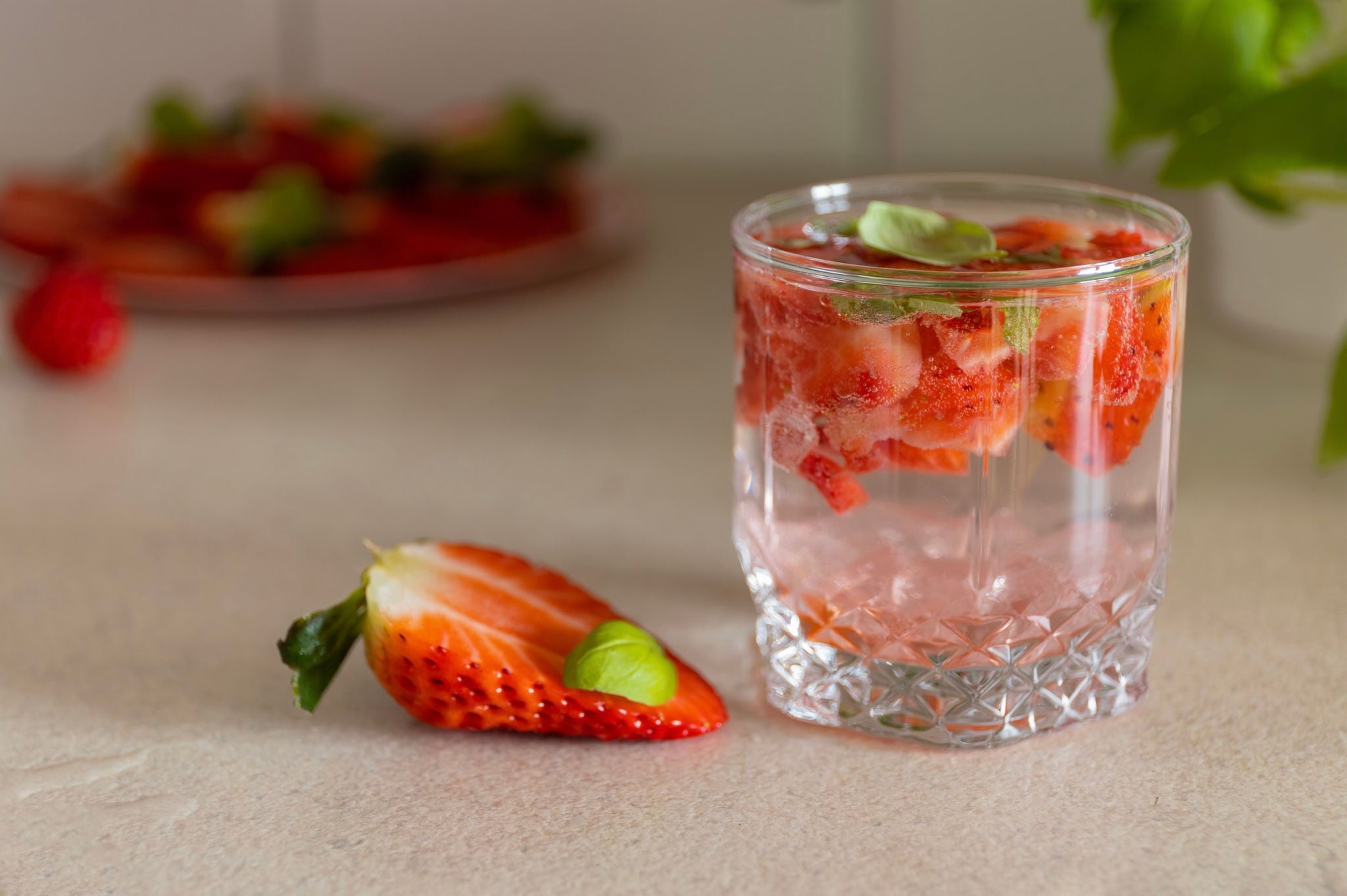 Glass with water, diced strawberries and mint leaves.