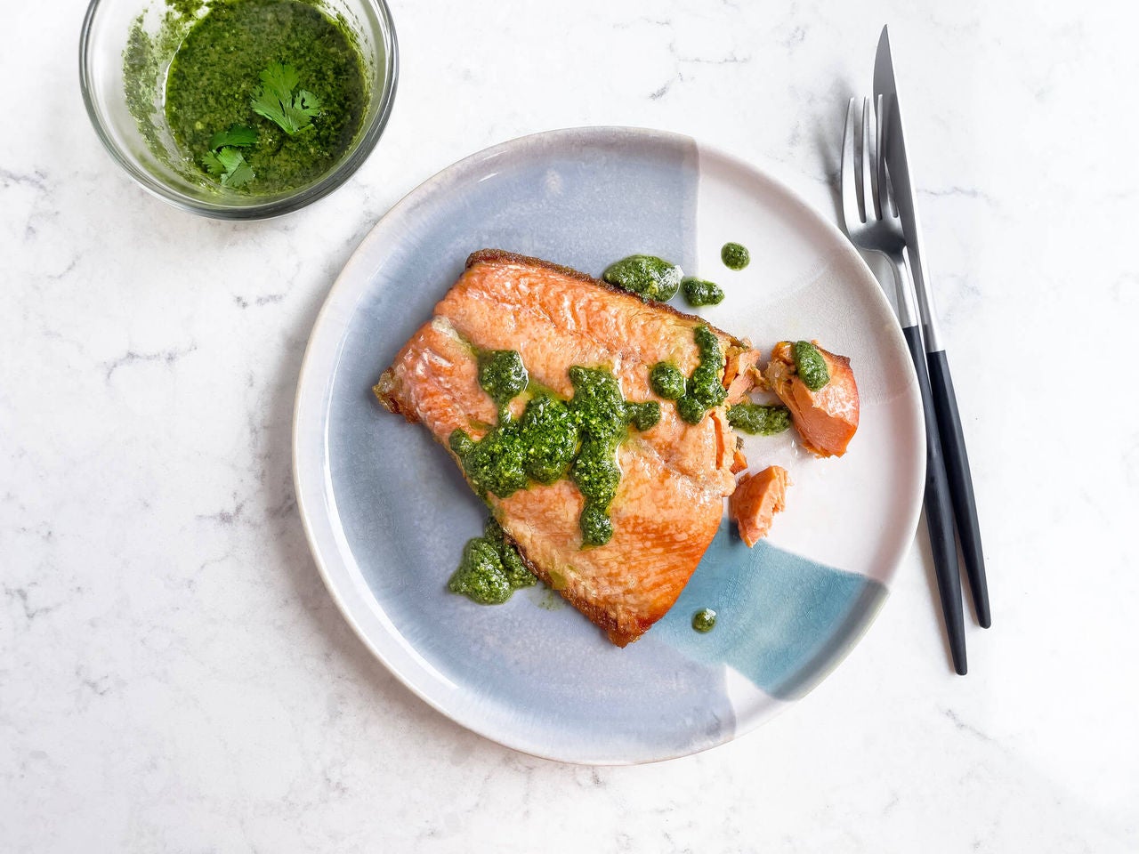 Salmon fillet with pesto sauce drizzled on top. 