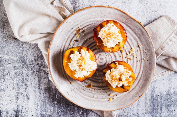Three grilled peach slices topped with ricotta.