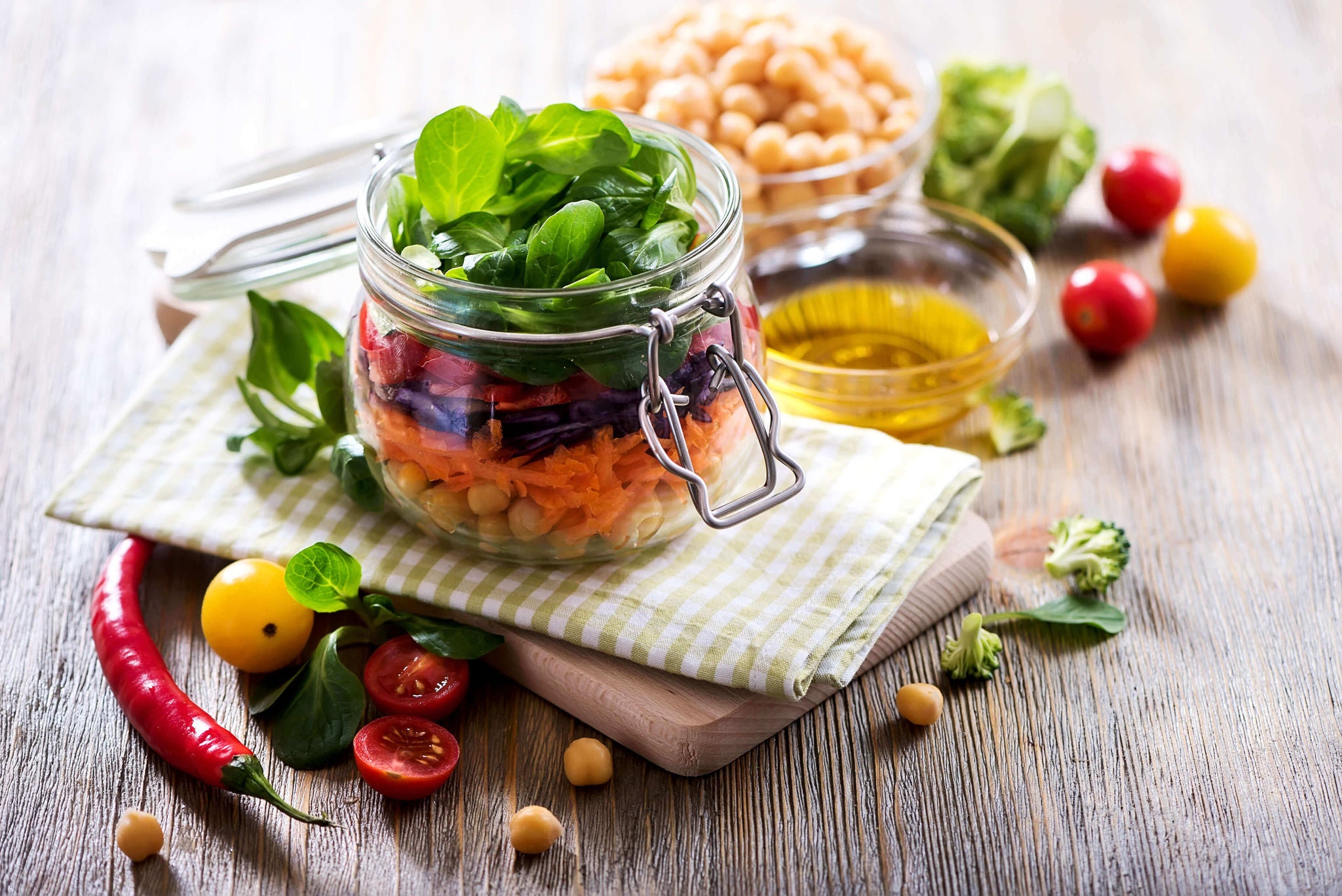 Layered mason jar salad with chickpeas, spinach, carrots, and beets