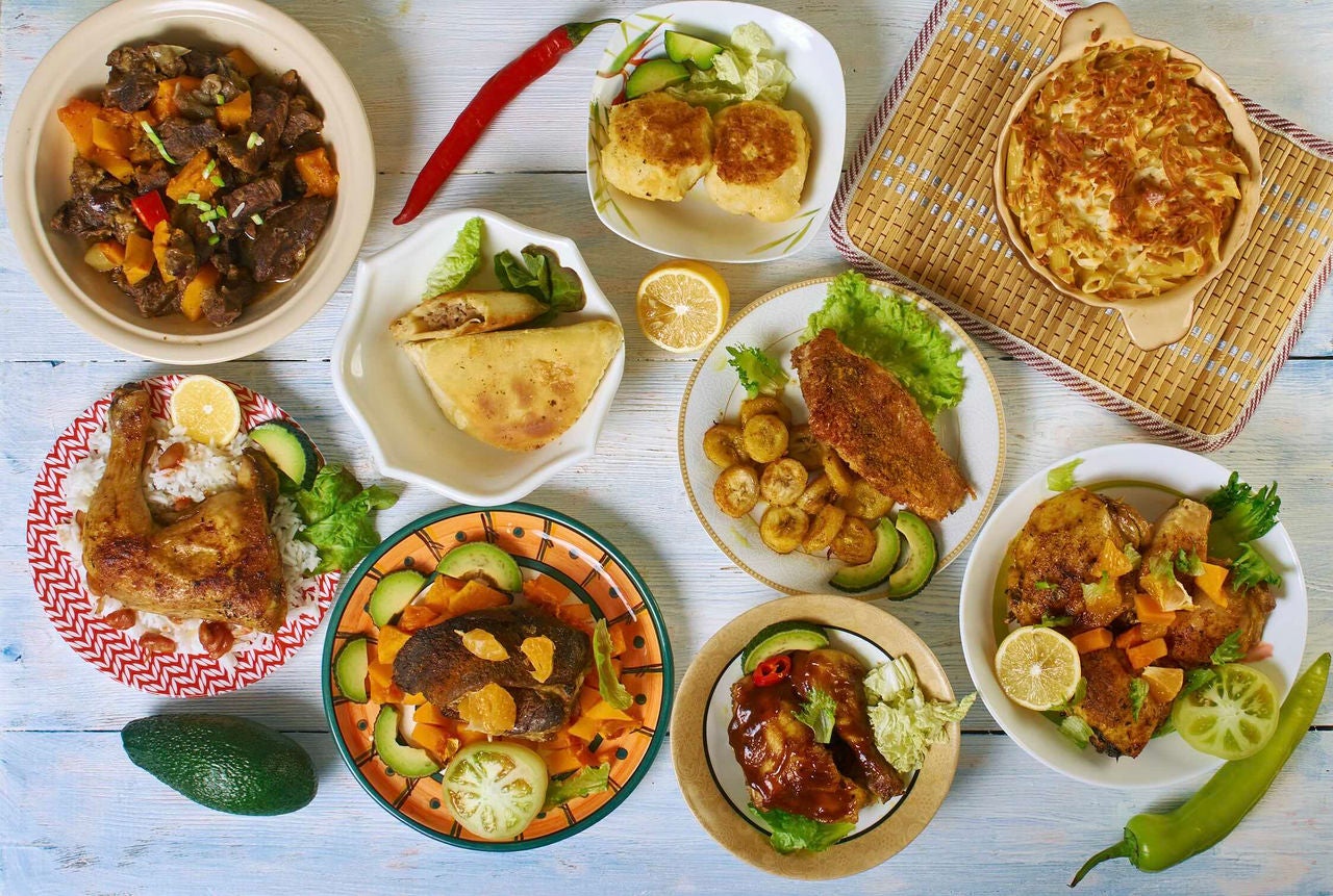 Overhead view of a table with various Caribbean dishes.