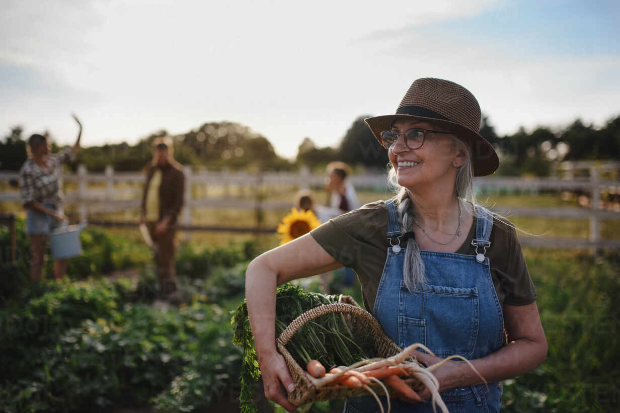 A senior female farmer with vegetable basket
