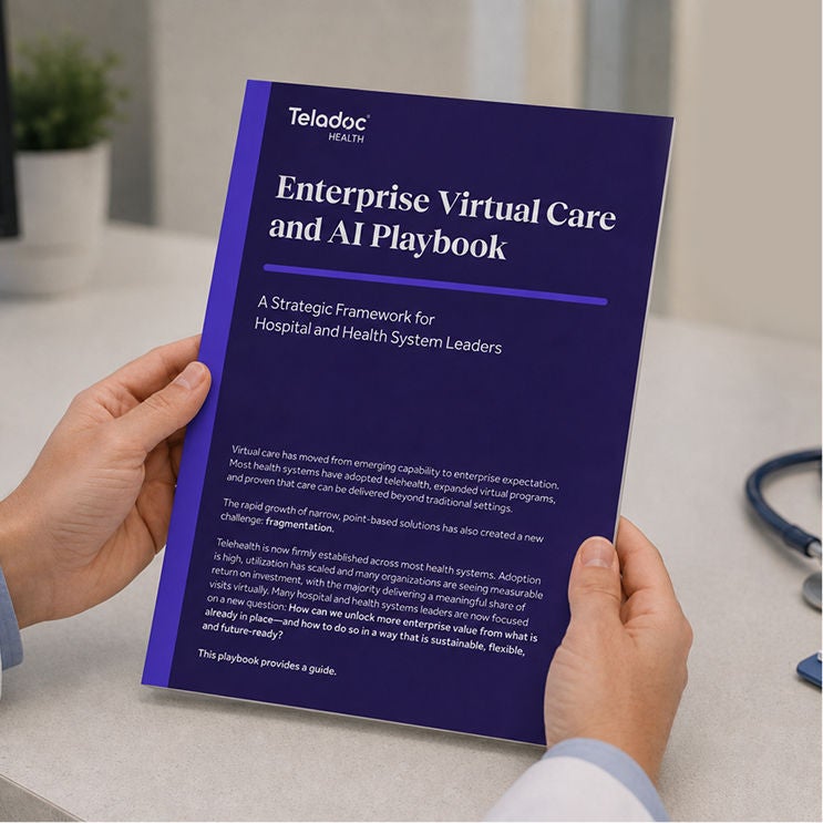Person holding the Teladoc Health Enterprise Virtual Care and AI Playbook booklet.