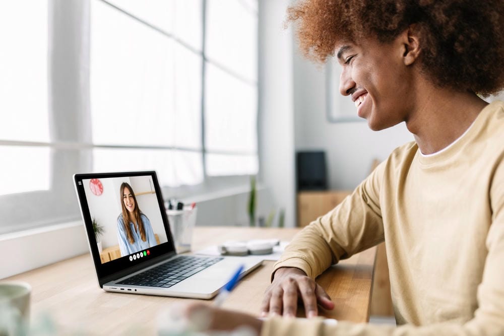 A man smiling while having a virtual therapy session