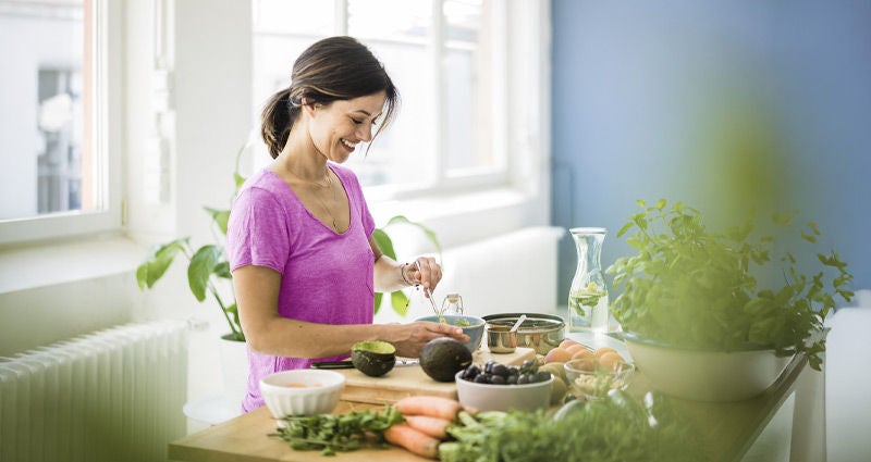 Young woman cutting avocados.