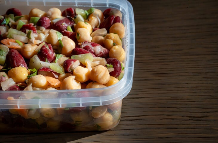 Tupperware container with a mixed bean salad.