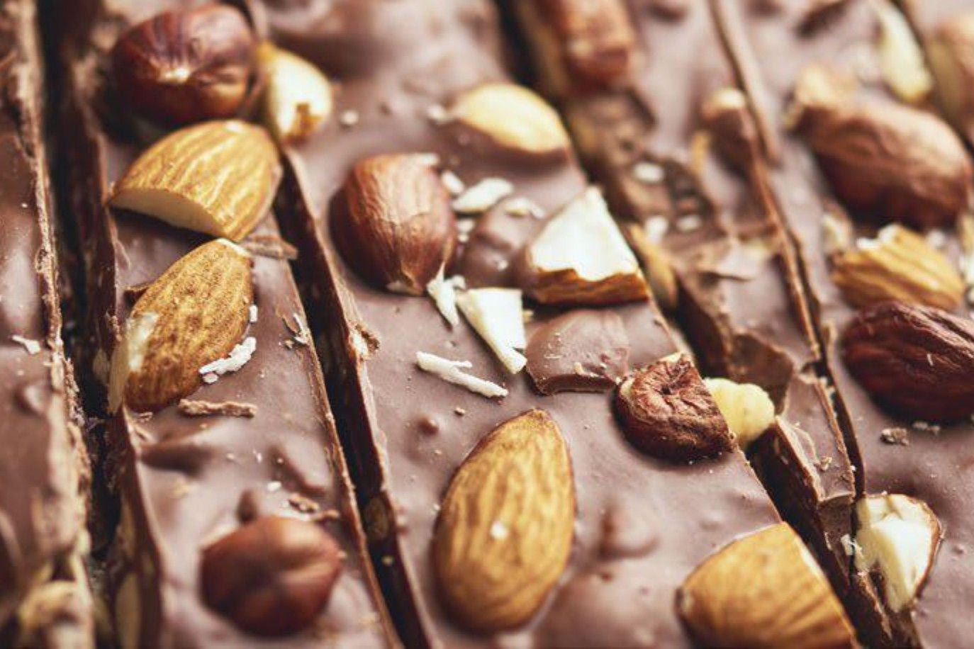 A close-up of chocolate bark featuring a mix of almonds and nuts, highlighting its crunchy texture and rich chocolate color.
