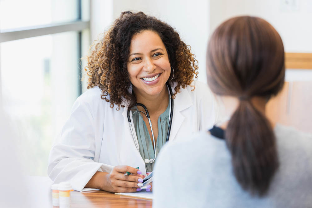 Smiling doctor consulting with a patient in a bright medical office.