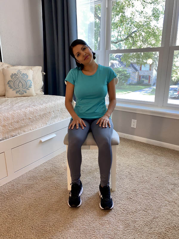 Woman with shoulder-length dark hair wearing a turquoise shirt and gray leggings