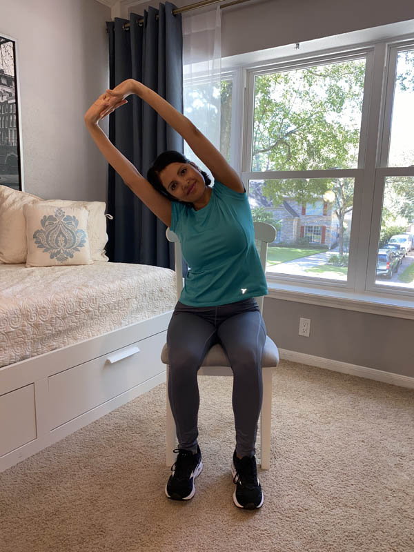 Woman with shoulder-length dark hair wearing a turquoise shirt and gray leggings