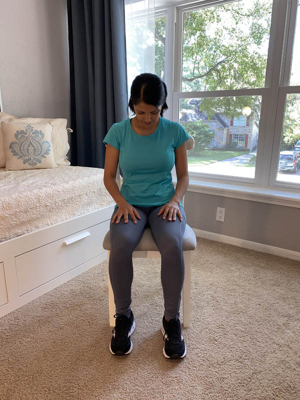 Woman with shoulder-length dark hair wearing a turquoise shirt and gray leggings