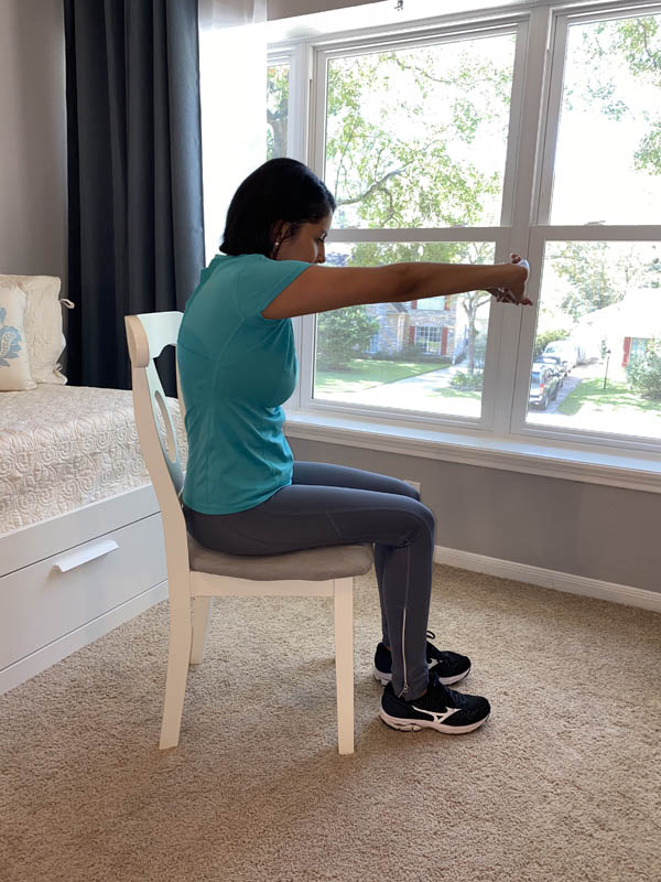 Woman with shoulder-length dark hair wearing a turquoise shirt and gray leggings