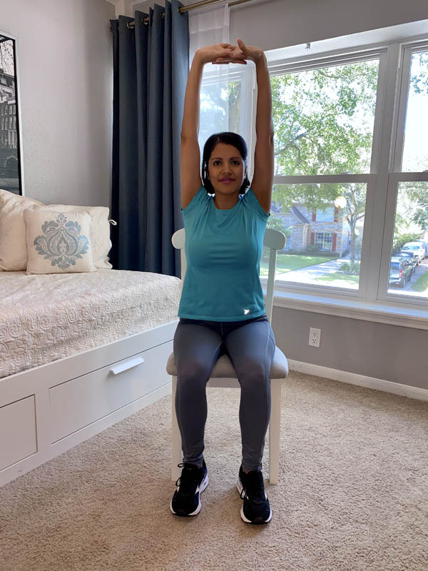 Woman with shoulder-length dark hair wearing a turquoise shirt and gray leggings