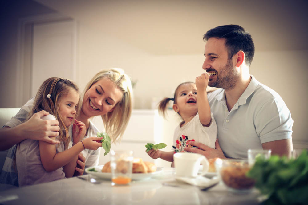 Happy family enjoying a healthy breakfast together at home, sharing smiles and fresh food.