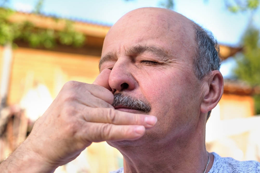 Older man practicing deep breathing exercises outdoors