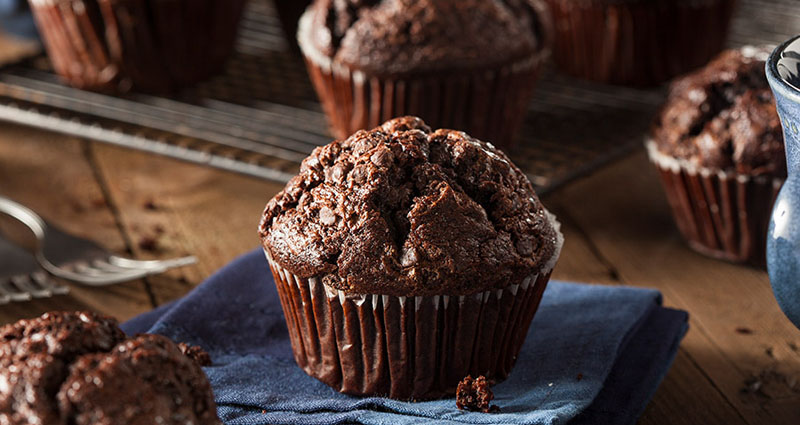 Dark chocolate muffins set on a table outdoors
