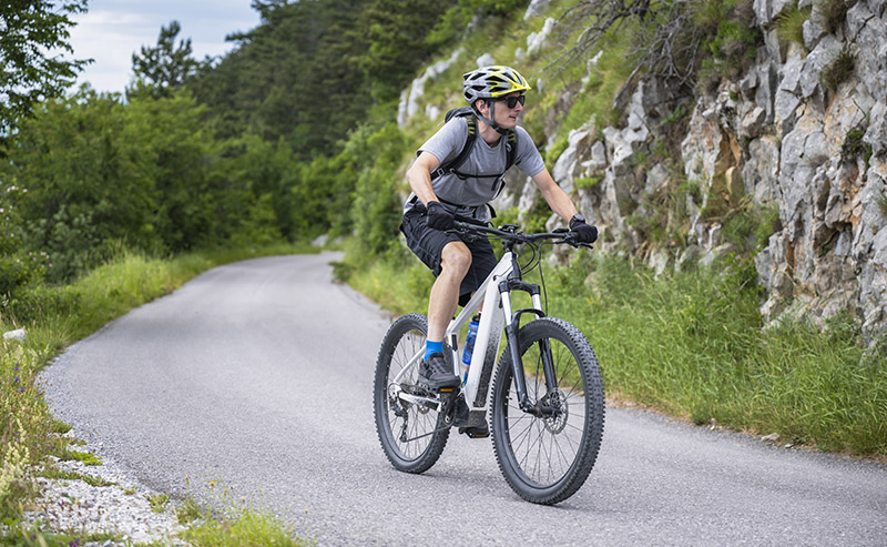 Man riding an electric mountain bike on the road.