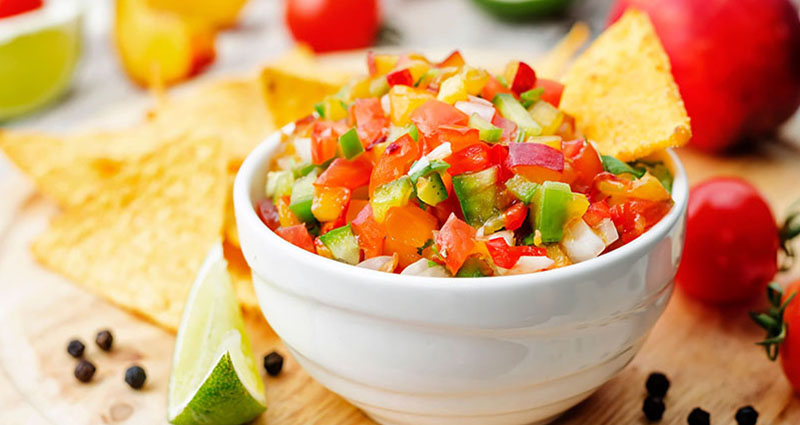 A bowl of garden fresh vegetable salsa served with tortilla chips