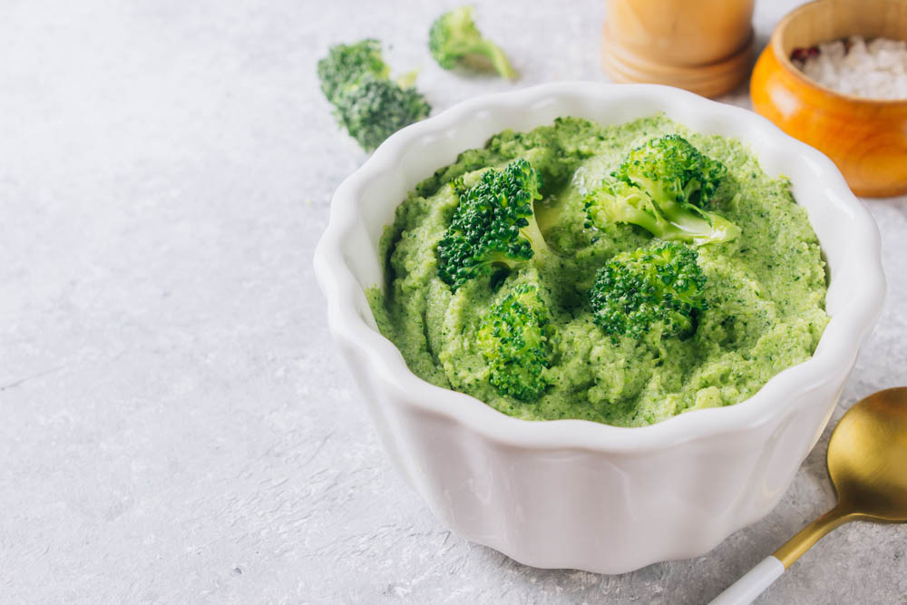 The concept of healthy food broccoli puree in a white bowl. Selective focus