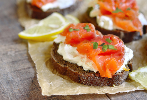 Sandwich with salted salmon and cream cheese on rustic background.