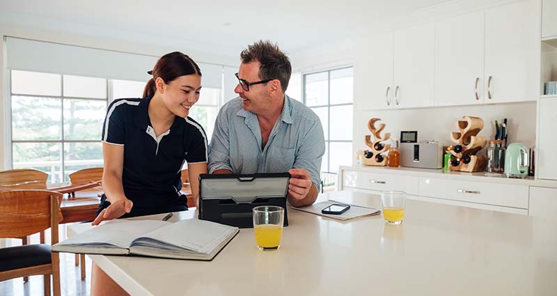 Father and daughter discussing health while looking at a laptop computer in the kitchen
