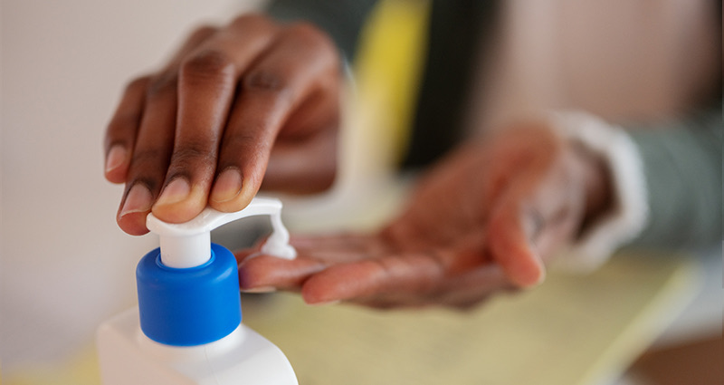 Close-up of person pumping lotion onto hand