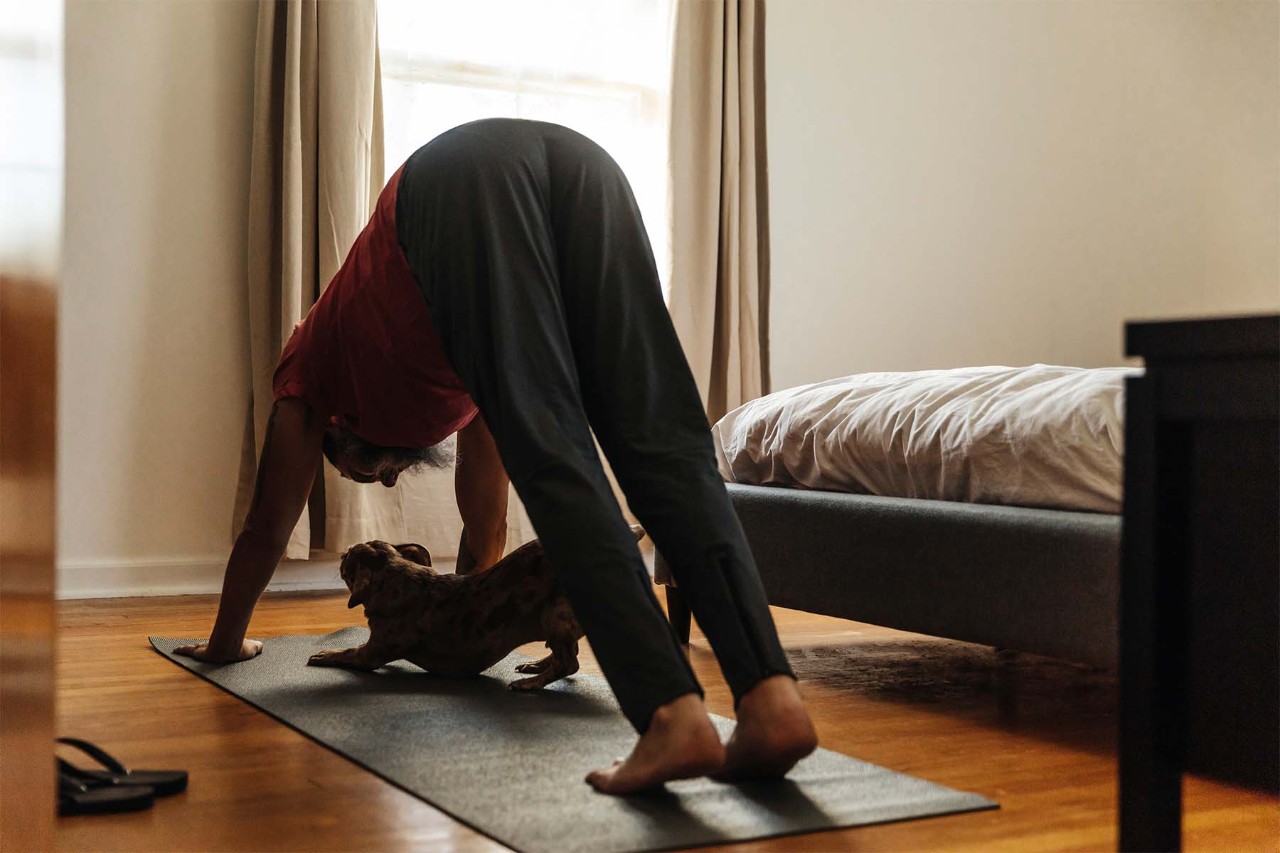 Person kneeling on the floor, reaching one arm forward and extending one leg back