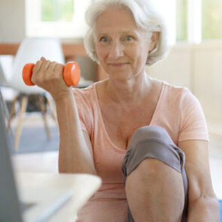 An older woman works out with a weight
