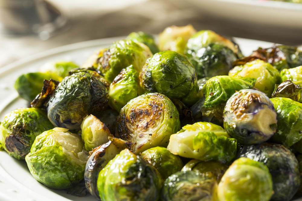 Close-up of roasted Brussels sprouts on a plate, showing their browned and crispy edges.