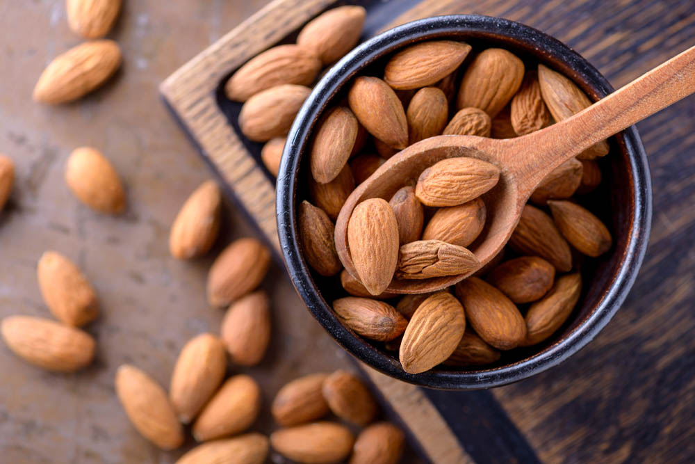Almonds on wooden spoon. Top view