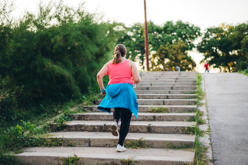 Woman jogging up outdoor steps in a park setting