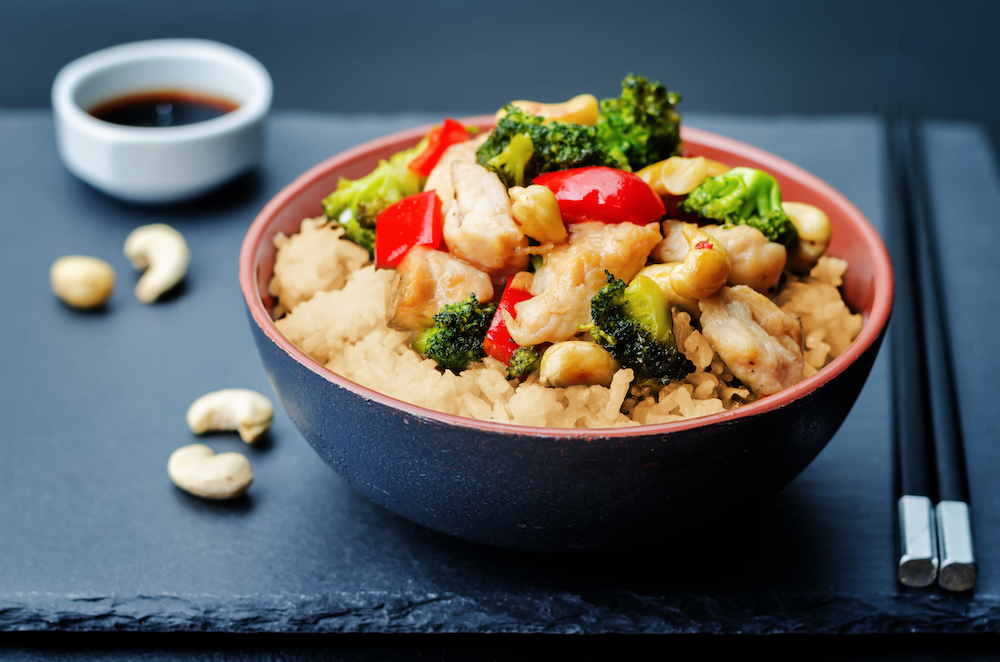 red pepper broccoli cashew chicken stir fry with rice. toning. selective Focus