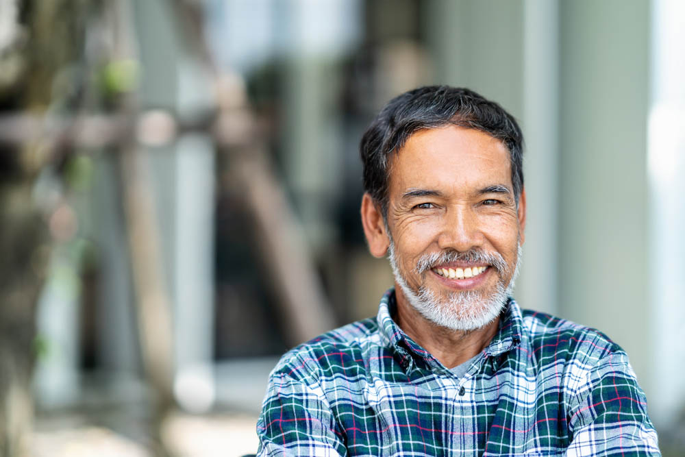 Portrait of happy mature man with white, grey stylish short beard looking at camera outdoor. Casual lifestyle of retired hispanic people or adult asian man smile with confident at coffee shop cafe.