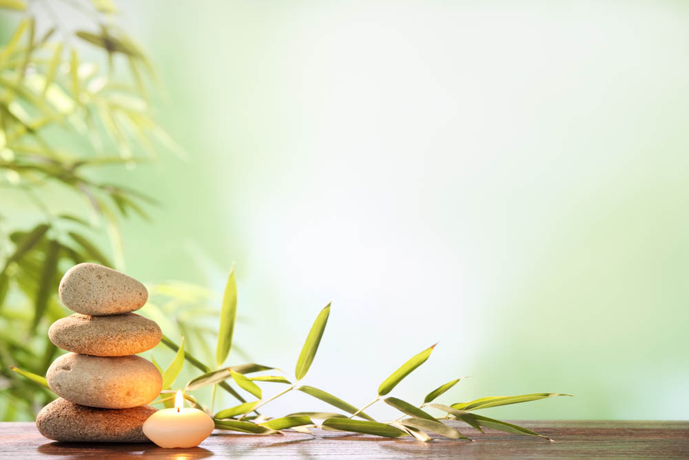 Spa still life with stacked of stone,burning candle and bamboo leaf