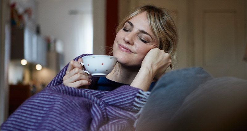 Woman on a sofa with a cup of tea