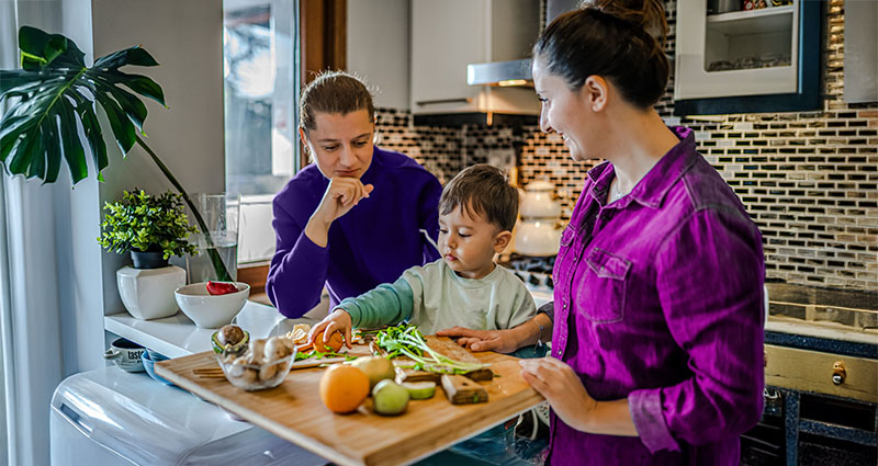 Women and child working on cutting board